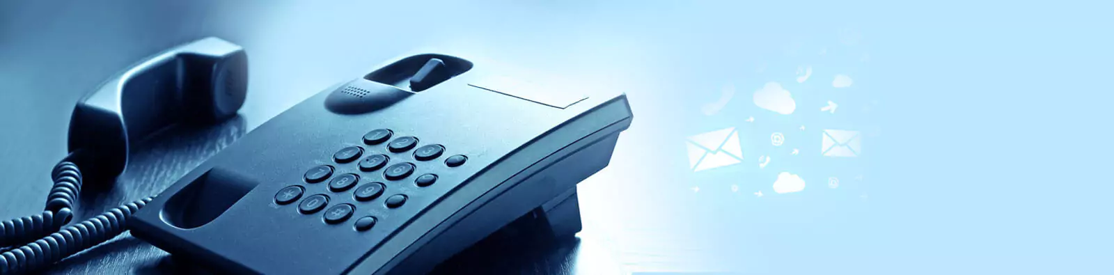 A landline phone with digital communication icons like emails and clouds in the background