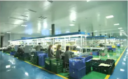 Interior view of Hemusun's factory showing workers at stations, blue bins, and production equipment