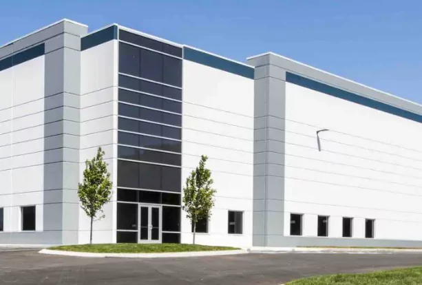 Modern industrial building with large windows and two small trees in front, representing Hemusun's factory